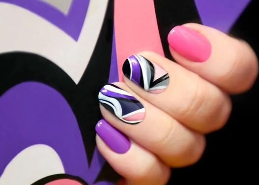 A woman is holding her nails with different designs on them.