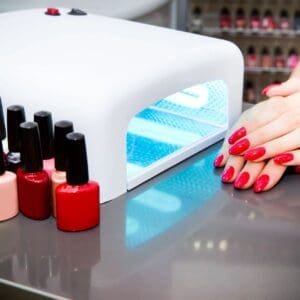 A person with red nails and their hands on top of the table.
