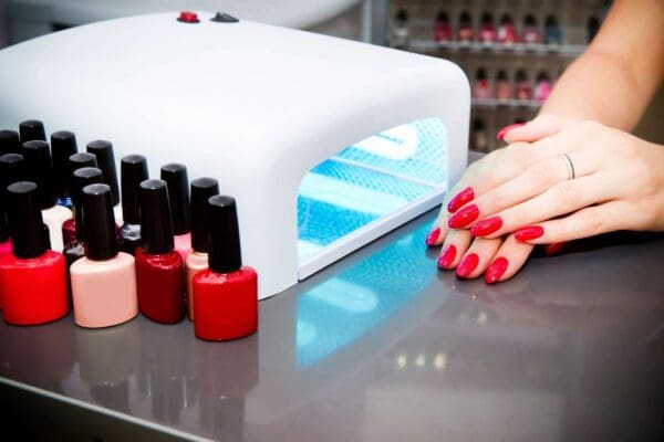 A person with red nails and their hands on top of the table.