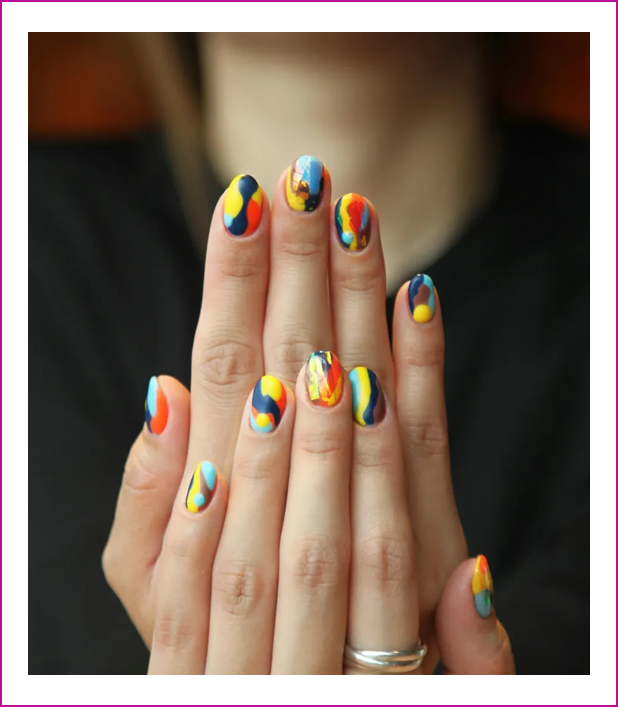 A woman with colorful nails is holding her hands.